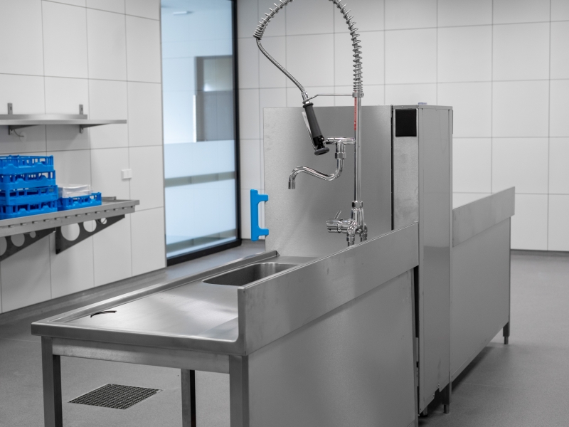Frei stehende Spülzeile mit Zu- und Ablaufverbau in Edelstahl (Wandhochzug rückseitig geschlossen)