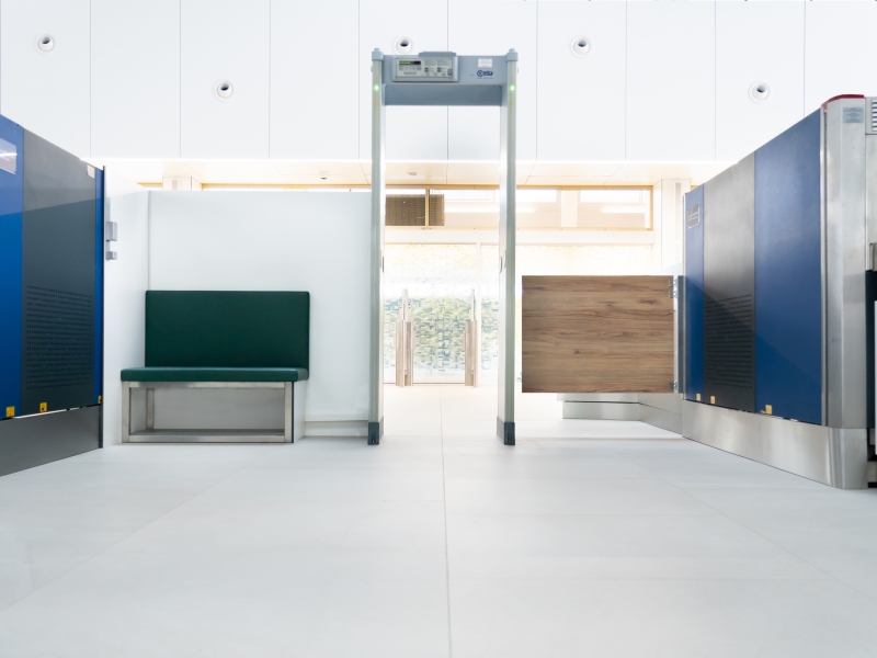 Flughafen Wien: Personenschleuse mit Sitzbank im Visitierbereich + Klapptür mit breitem Durchgang für Rollstuhl und Kinderwagen