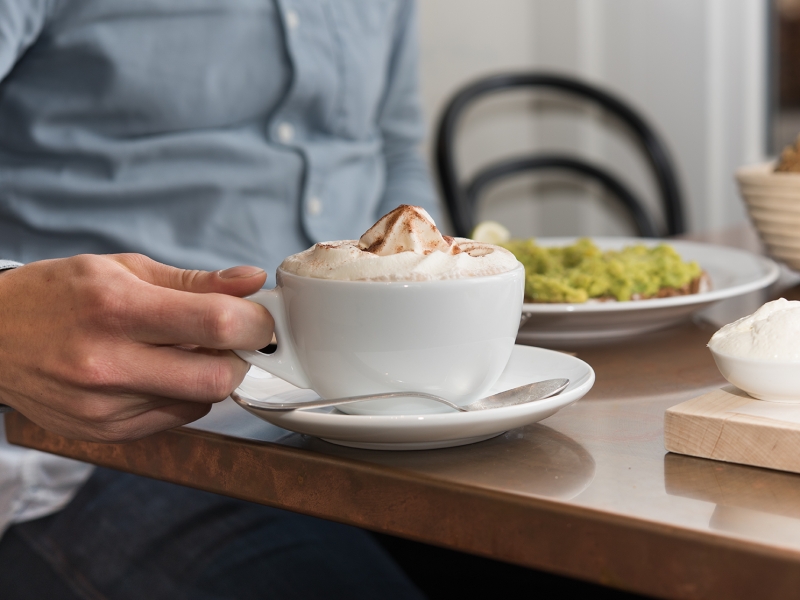 Detailaufnahme von Kaffeetasse auf Kupfer-Tischplatte
